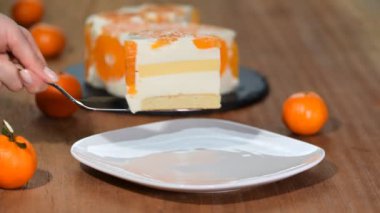 Ahşap masada beyaz plaka izole mandalina kek bir parçası