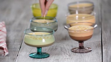 Lezzetli çikolata karamel Mousse ahşap arka plan üzerinde cam badem ile tepesinde.