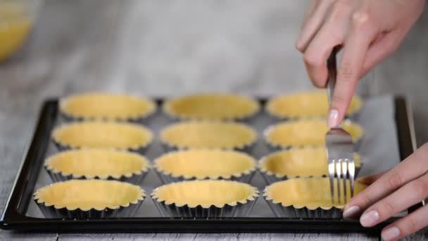 Piquez la base de l'étui à pâtisserie partout avec une fourchette. Fabrication de tartelettes série . — Video