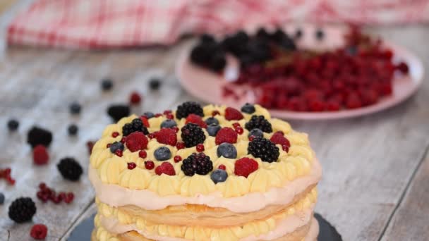 Chef che prepara torte di pasta sfoglia con crema pasticcera e ribes, lamponi, more, mirtilli. Delizioso dessert . — Video Stock