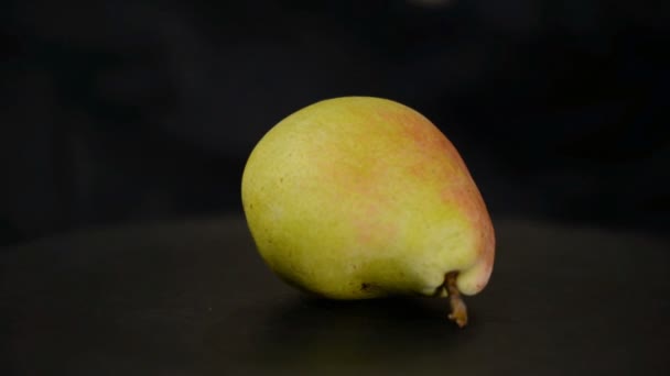 Close-up of a ripe juicy pear rotate on a black background. — Stock Video