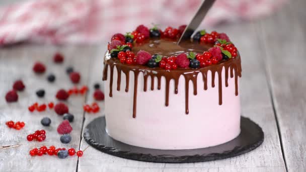 Gyönyörű házi készítésű sütemény nyári bogyóval, csokoládé fagyosan a fehér asztalon. — Stock videók