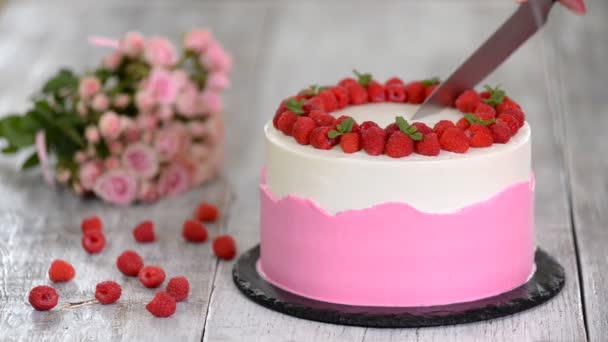 Tårta med vispad rosa grädde, färska hallon och mynta. — Stockvideo