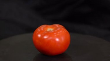 Siyah arka planda domates rotasyonu.