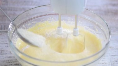 Un hamur ekleme. Şef dökülen beyaz un kase hamur eller.