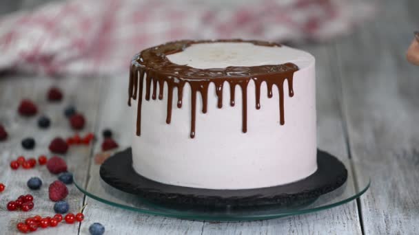 Gelado de chocolate no bolo. Bolo branco coberto com chocolate e creme. Decoração de bolo de chocolate . — Vídeo de Stock