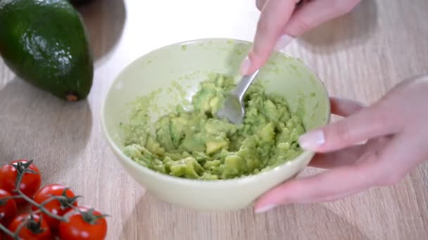 Gros plan de femme mains écrasant avocat avec fourchette dans le bol — Video