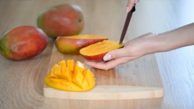 Kadın Şefler ahşap kesme tahtası üzerinde mango dilim eller. Yaz sağlıklı vegan meyve salatası.