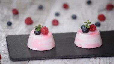 Taze ahududu, yaban mersini ve nane ile dekore lezzetli berry mus tatlılar.
