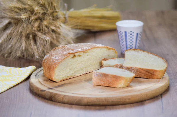 Fresh homemade baked bread and sliced bread with milk on rustic white wooden table. — Stockfoto