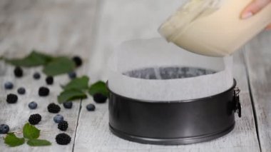 Kadınların elleri kek kalıbına döküyor, pişirmeye hazır..