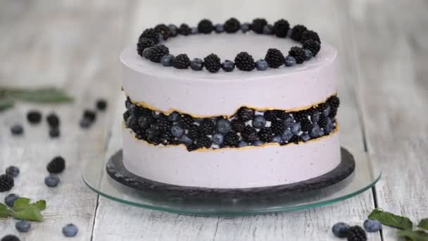 Violetti kaunis kakku koristeltu marjoilla, karhunvatukoilla ja mustikoilla päälle . — kuvapankkivideo