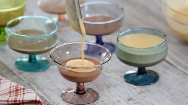 Şef bir bardak karamel krem mus dökme, yakın. Karamel krem mus tatlı sıcağa bir bardak çikolata ile yakın