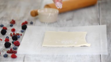 Şef parşömen kağıt üzerinde Puff Böreği haddeleme. Böğürtlenli Mille Feuille yapma