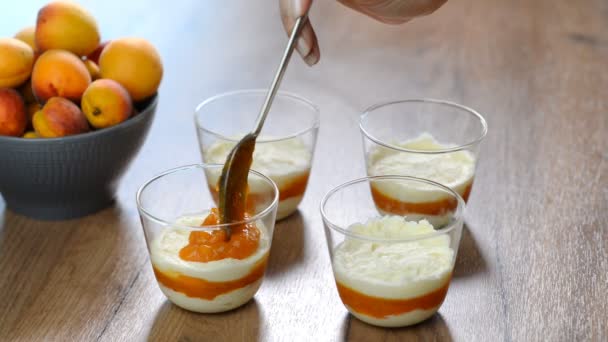 Banketbakker meisje maakt abrikoos dessert in een glas — Stockvideo