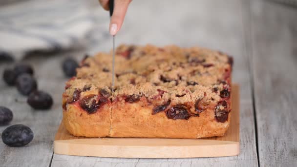 Donna che taglia una torta di prugne sul tagliere di legno . — Video Stock