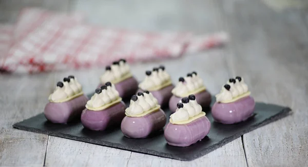 Blueberry mousse taart gegarneerd met bosbessen en slagroom bij bakkerij shop. — Stockfoto