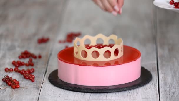 Pastel de mousse con grosellas rojas sobre fondo blanco. Decoración de pasteles con grosella roja . — Vídeos de Stock