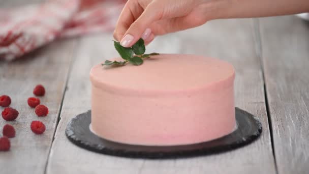 Il pasticcere decora la torta rosa con le rose. Serie. — Video Stock