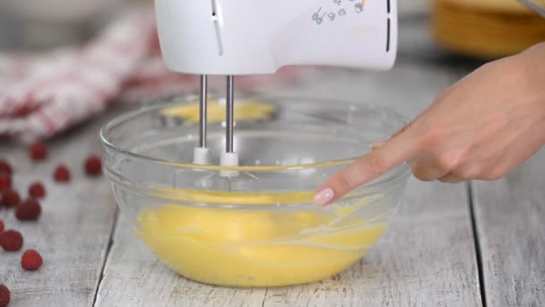 Cozinhar e conceito de casa. Fechar, mulher bater creme com misturador de mão. Preparação de nata doce . — Vídeo de Stock