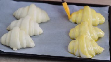 Bir Baker boyama Bir kafede pişmiş olacak kruvasan üzerine Yumurta yıkama.