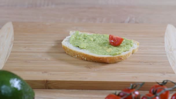 Vegan sandwich met avocado en groenten op houten achtergrond. — Stockvideo