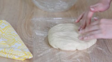 Cook kruvasan yapmak için yapışkan film hamur sarar