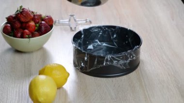 Bir kadın kek için jöle dolgu yapmak için bir kalıp içine çilek jöle döker.