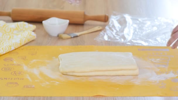 Bakker rolt het deeg uit voor croissants. Proces van het maken van zelfgemaakte croissants met boter. — Stockvideo