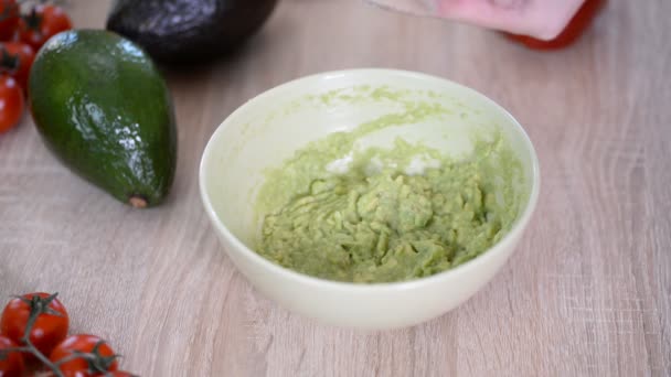 Frau fügt pürierte Avocado Gewürze hinzu — Stockvideo