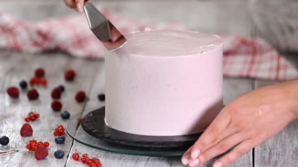 Die Hände des Konditors verzieren die Torte mit weißer Sahne. Bäcker, Konditor. — Stockvideo