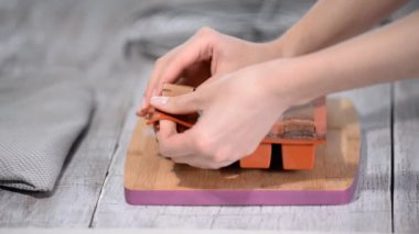 Kadın elleri esnek silikon kalıp, yakın çekim kare mus kek alarak.