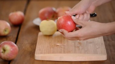 Yemek elma bir ahşap tahta üzerinde peeling eller.