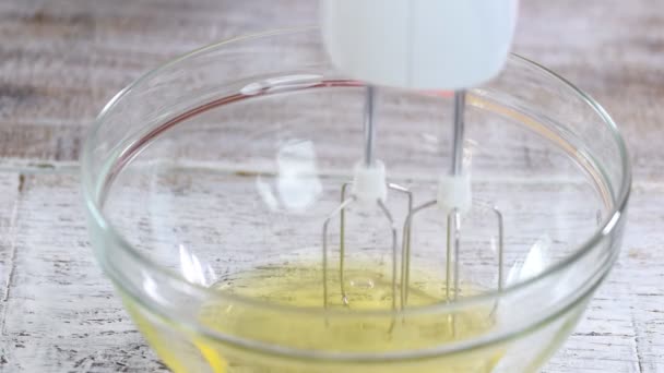 Шеф-повар выбивает яичные белки в стеклянную миску. . — стоковое видео