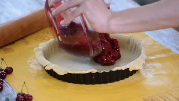 Preparando em casa torta de cereja caseira fresca e doce em um balcão de cozinha colocando dentro de cerejas vermelhas . — Vídeo de Stock