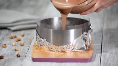 Şekerlemeci pasta halkasına çikolatalı mus döküyor. Mus kek yapma süreci.