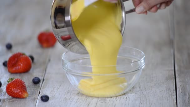 Hausgemachte Vanillepudding in Glasschale gießen. — Stockvideo