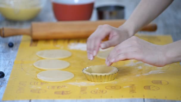 Cocinero pastelero haciendo tartaletas, poniendo la masa en platos para hornear . — Vídeos de Stock
