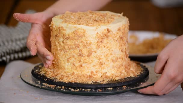 홈 키친에서 케이크 나폴레옹을 만드는 케이크는 부스러기의 미세한 뿌리로 뿌려져 있습니다. 퍼프 페이스트리. — 비디오