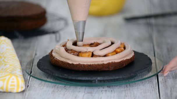 Mujer en la cocina haciendo pastel de chocolate con relleno de plátano . — Vídeo de stock