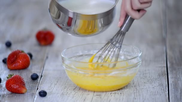 Φτιάχνω κρέμα για τάρτα. Ρίχνουμε ζεστό γάλα σε ένα μπολ με μείγμα αυγών. — Αρχείο Βίντεο