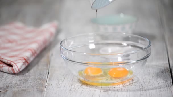 Kvinnliga händer slå med mixer ägg med socker för att göra deg. Ägg och socker i blandningsskålen. — Stockvideo