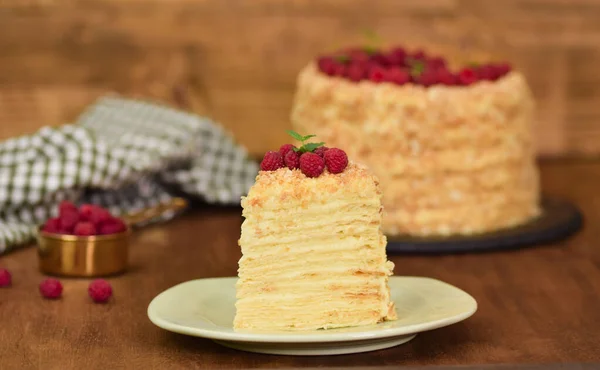 Trancher la confiserie Napoléon Gâteau décoré de framboise. Portion de gâteau à la crème anglaise . — Photo