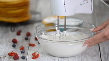 Kadın pasta şefi el çırpma makinesiyle kremayı yener..