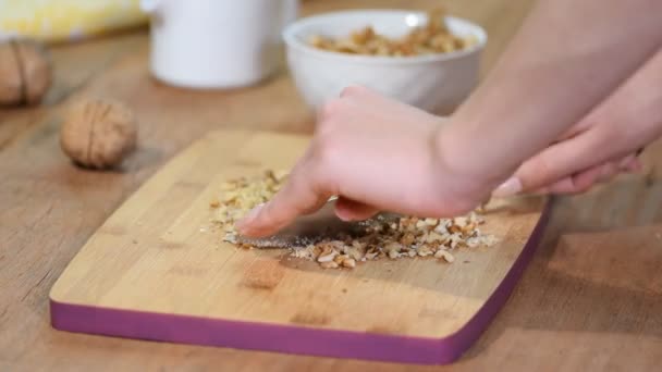 Hands cut a walnuts on board in the kitchen. — Stock Video