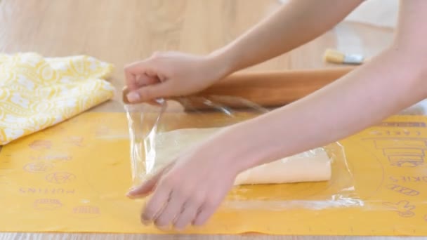 Woman wraps dough in clear film. Making puff pastry, series. — Stock Video