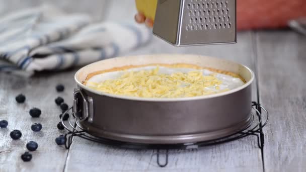 Mani femminili grattugiare pasta sfoglia con una grattugia sulla torta di formaggio. Preparazione della torta di formaggio sbriciolata . — Video Stock