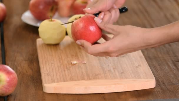 Manos pelando una manzana cocida en una tabla de madera . — Vídeos de Stock