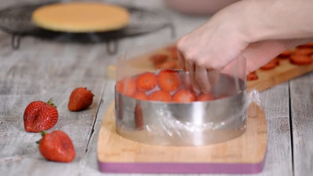 Confeiteiro na cozinha fazendo bolo de mousse de morango . — Vídeo de Stock