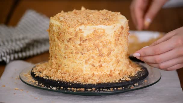 Haciendo un pastel Napoleón en la cocina del hogar, el pastel está espolvoreado con finas migajas. Pastel de hojaldre . — Vídeos de Stock